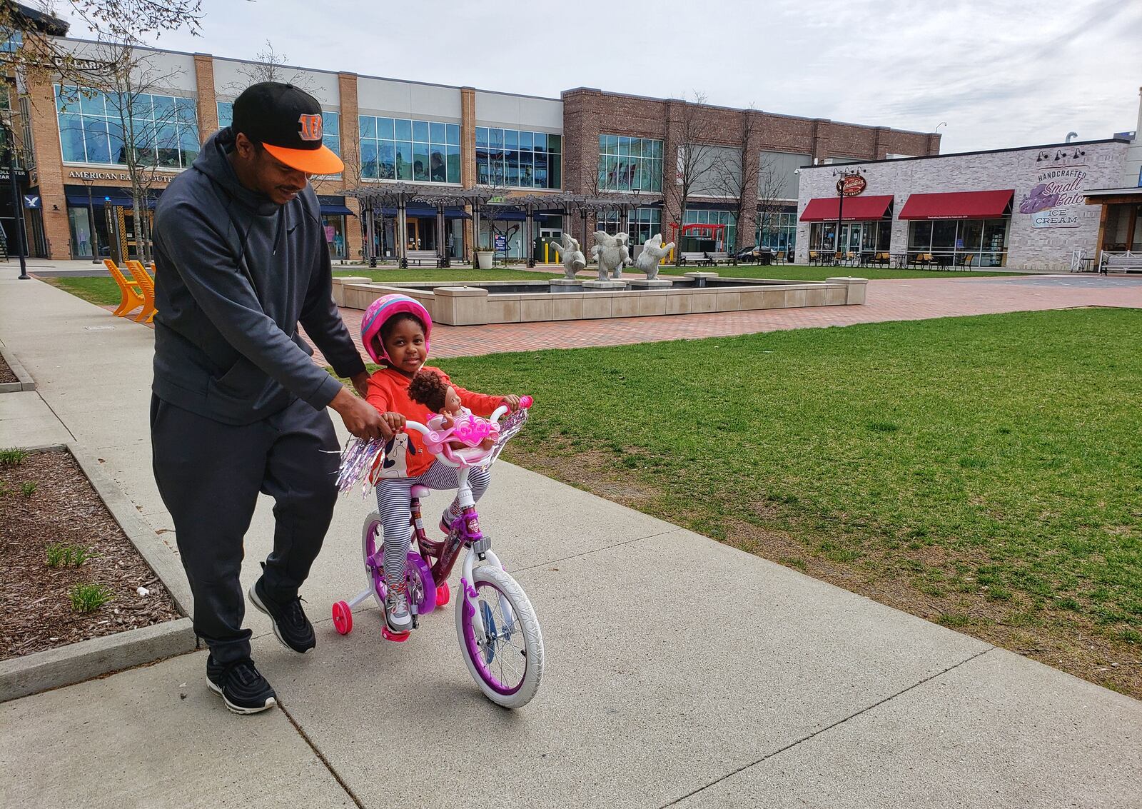 Jimmy Hardy walks as his daughter, Ava, rides her bike at Liberty Center Thursday, March 26, 2020 in Liberty Township. Most businesses are closed at Liberty Center due to the to Stay-At-Home order in place. The coronavirus pandemic is really just in its infancy here but Butler County governments are starting to take steps in case sales, income tax and other revenues tumble under shelter in place orders.
The largest revenue source for county government is sales tax. While people are still allowed to shop, and are in some cases are spending a lot hoarding things like toilet paper, the projected $44 million in Butler County sales tax revenues is sure to plummet the longer the pandemic lingers. NICK GRAHAM / STAFF