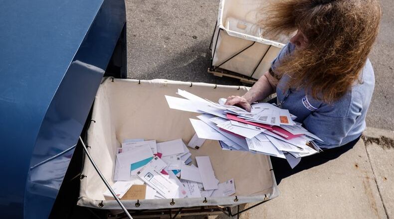 FILE PHOTO: A U.S. Postal Service worker empties a drop box in Kettering. JIM NOELKER/STAFF