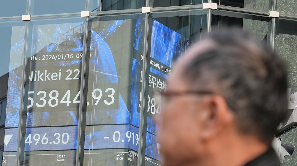 A person walks in front of an electronic stock board showing Japan's Nikkei index at a securities firm Thursday, Jan. 15, 2026, in Tokyo. (AP Photo/Eugene Hoshiko)