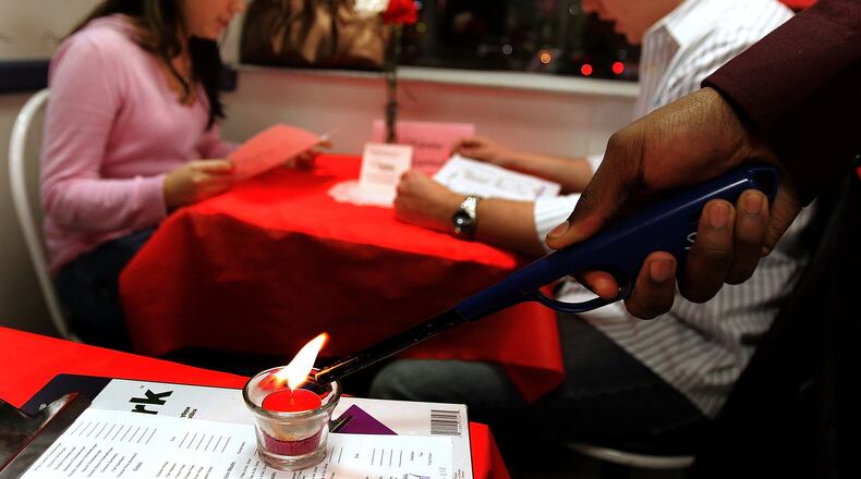 DES PLAINES, IL - FEBRUARY 14: A candle is lit near the table of Leslie Adams and Rob Dockery during a Valentine's Day dinner at a White Castle restaurant February 14, 2006 in Des Plaines, Illinois. For Valentine's Day, numerous White Castle restaurants nationwide took dinner reservations offering candlelit dining with individual servers as well as hostess seating. (Photo by Tim Boyle/Getty Images)