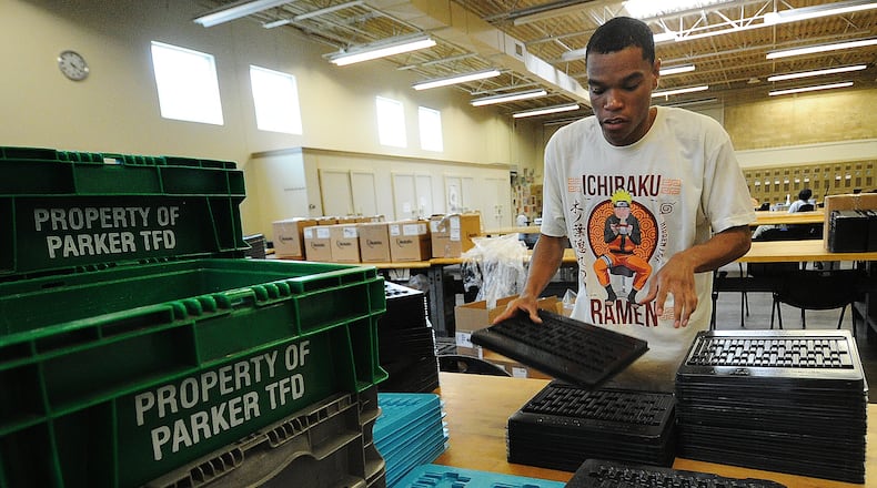 Damien, a worker at Better Living Home Health, stacks plastic trays that will be boxed and shipped away for a company. He is paid through the federal 14c program. MARSHALL GORBY\STAFF