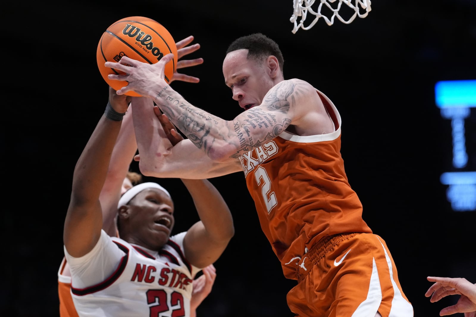 Texas guard Chendall Weaver (2) rebounds the ball from North Carolina State forward Ven-Allen Lubin (22) during the first half in a First Four college basketball game in the NCAA Tournament, Tuesday, March 17, 2026, in Dayton, Ohio. (AP Photo/Kareem Elgazzar)