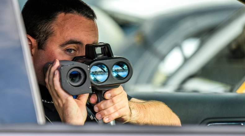 New Miami Police Officer Mark Bennett uses their Lidar photo laser speed enforcement camera along US 127 Wednesday, Nov. 30 in New Miami. A court hearing regarding the old freestanding speed cameras previously used by New Miami is scheduled for Dec. 1. NICK GRAHAM/STAFF