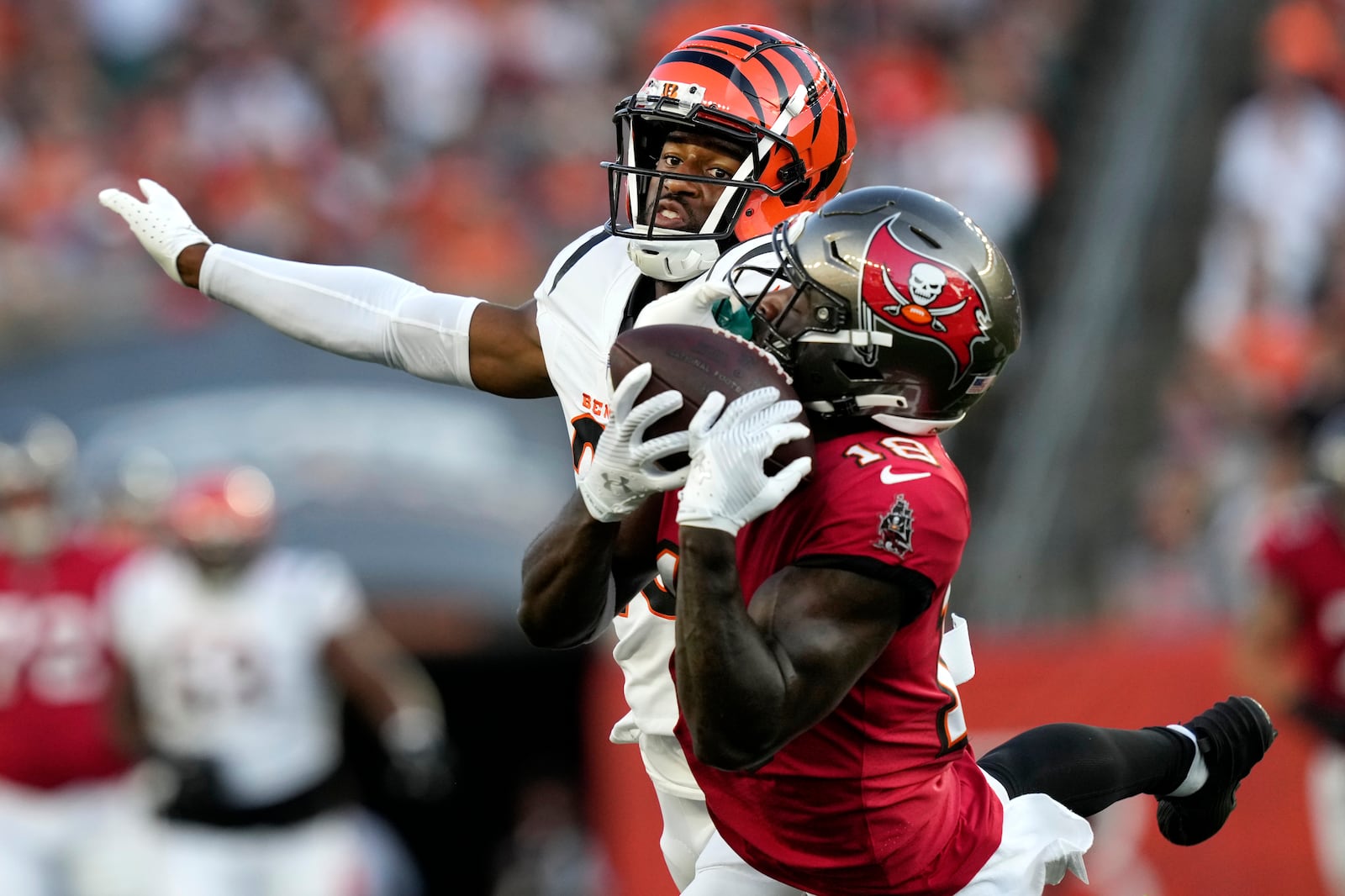 Tampa Bay Buccaneers wide receiver Rakim Jarrett (18) makes a catch as he is defended by Cincinnati Bengals cornerback Dax Hill in the first half of an NFL preseason football game Saturday, Aug. 10, 2024, in Cincinnati. (AP Photo/Carolyn Kaster)