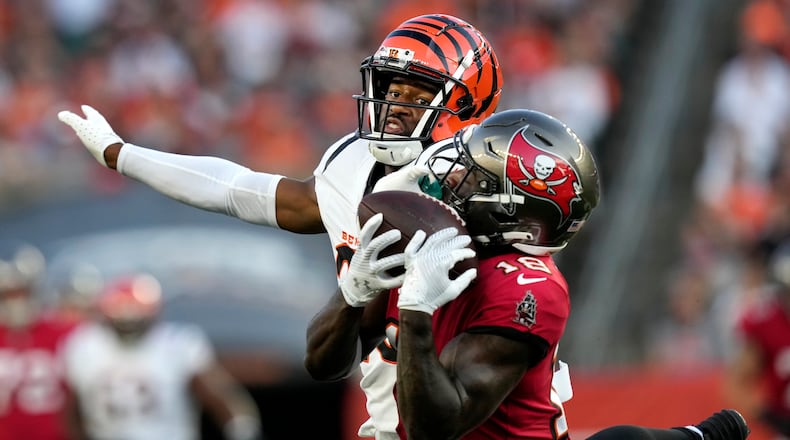 Tampa Bay Buccaneers wide receiver Rakim Jarrett (18) makes a catch as he is defended by Cincinnati Bengals cornerback Dax Hill in the first half of an NFL preseason football game Saturday, Aug. 10, 2024, in Cincinnati. (AP Photo/Carolyn Kaster)