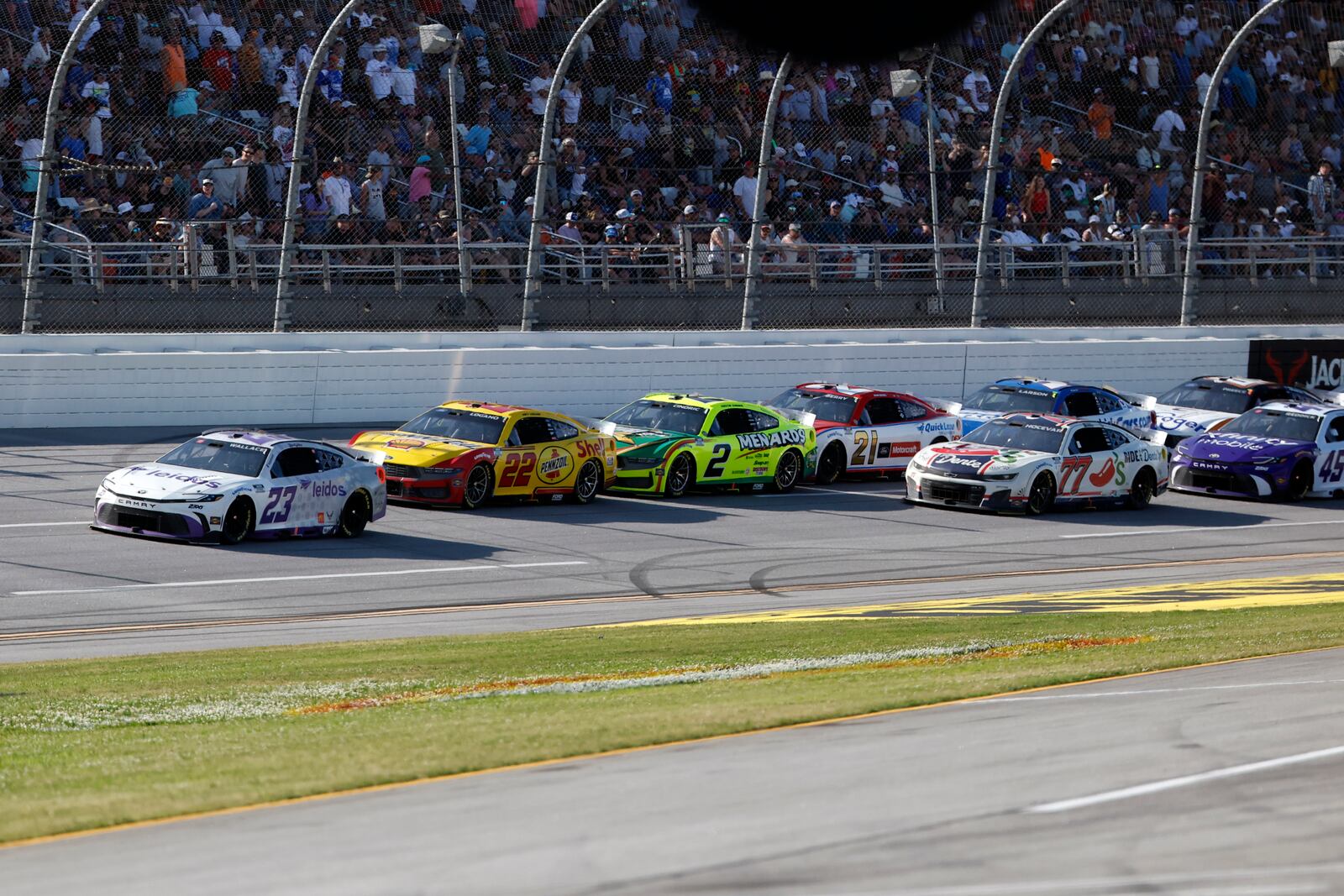 Bubba Wallace (23) leads the pack to win Stage 2 during a NASCAR Cup Series auto race at Talladega Superspeedway, Sunday, April 27, 2025, in Talladega, Ala. (AP Photo/Butch Dill)