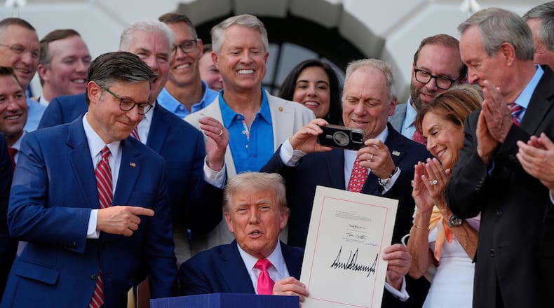 FILE - President Donald Trump holds his signed signature bill of tax breaks and spending cuts at the White House, July 4, 2025, in Washington, surrounded by members of Congress. (AP Photo/Julia Demaree Nikhinson, File)