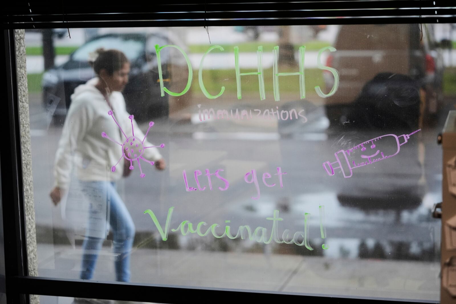 A message encouraging vaccinations is written on a window at the Dallas County Health and Human Services offices in Dallas, Friday, April 4, 2025. (AP Photo/LM Otero)