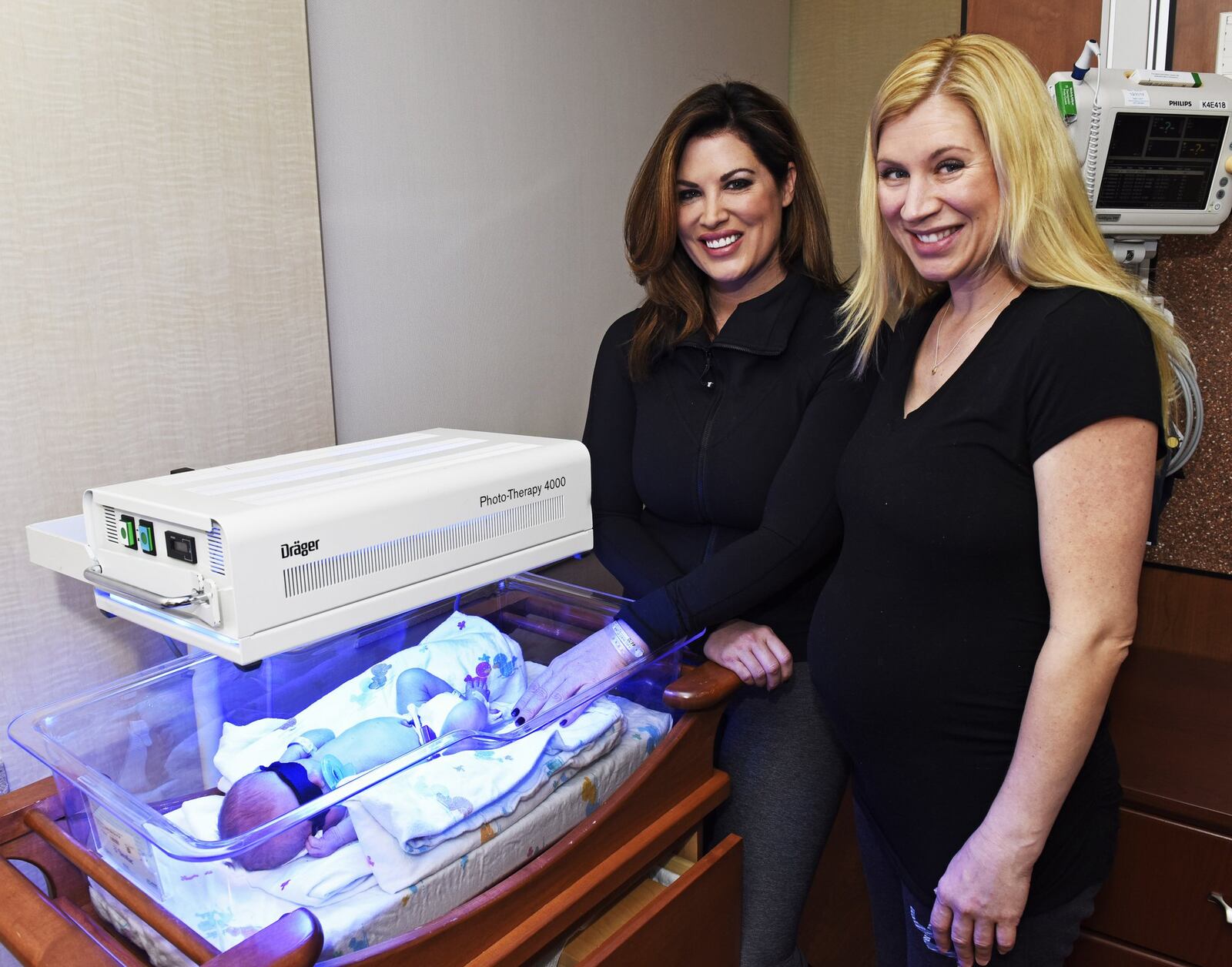 Emily Simpson, left, stands with her sister Sara Moffitt, who served as a surrogate for Simpson’s twin boys, Lucas and Keller, who were born Sunday at Kettering Medical Center. Moffitt also was a surrogate for Simpson’s daughter who was born almost 2 years ago. NICK GRAHAM/STAFF