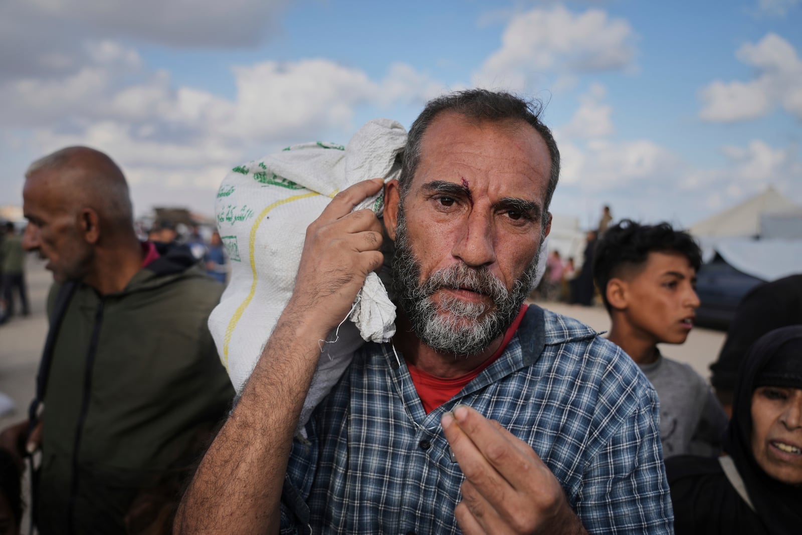 Palestinians carry bags filled with food and humanitarian aid provided by the Gaza Humanitarian Foundation, a U.S.-backed organization approved by Israel, in Khan Younis, southern Gaza Strip, on Tuesday, June 3, 2025. (AP Photo/Abdel Kareem Hana)