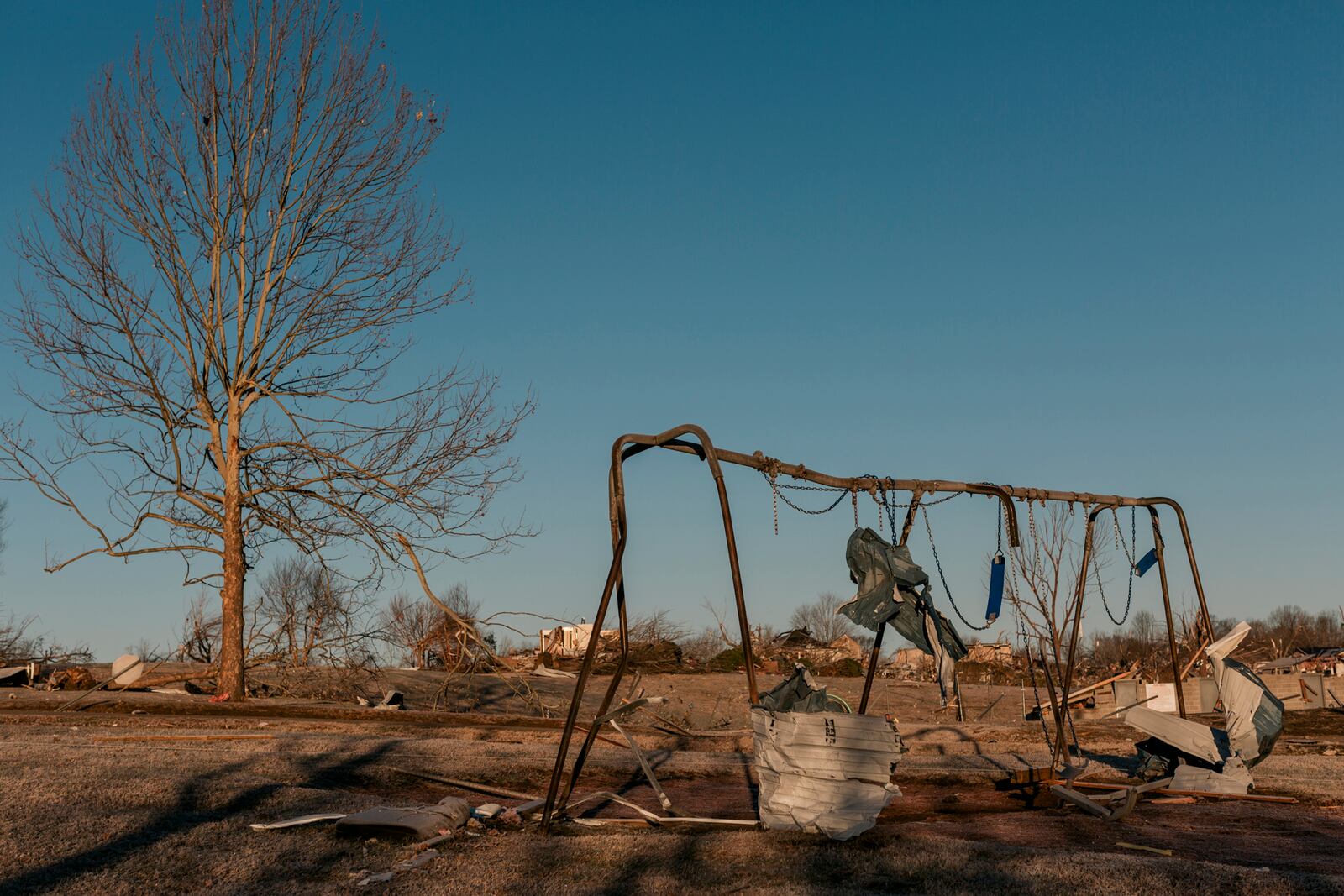 A swing set damaged by a tornado in Dawson Springs, Ky., on Monday, Dec. 13, 2021, where a tornado flattened much of the town on Friday night. After grimly fluctuating death tolls since Friday’s devastating swarm of tornadoes, Gov. Andy Beshear of Kentucky said on Monday that there were 64 confirmed deaths in the state, though he expected that number to rise as crews continued to search through the ruins. (William Widmer/The New York Times)