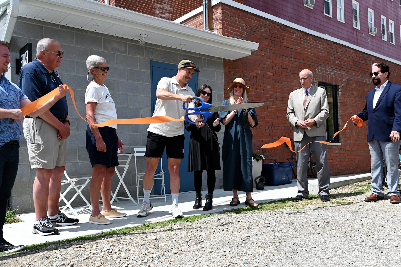 Spoken Bicycles opened its new shop in downtown Hamilton at 116 S. 2nd Street Rear, behind the U.S. Bank on Court Street. Pictured is owner Otto Bohn, (center with scissors) cuts a ribbon formally opening his shop. Bohn opened the shop six years ago in Middletown before converting to a mobile shop for a year. The shop opened in Hamilton on Friday, June 6, 2025, with a ribbon cutting. MICHAEL D. PITMAN/STAFF