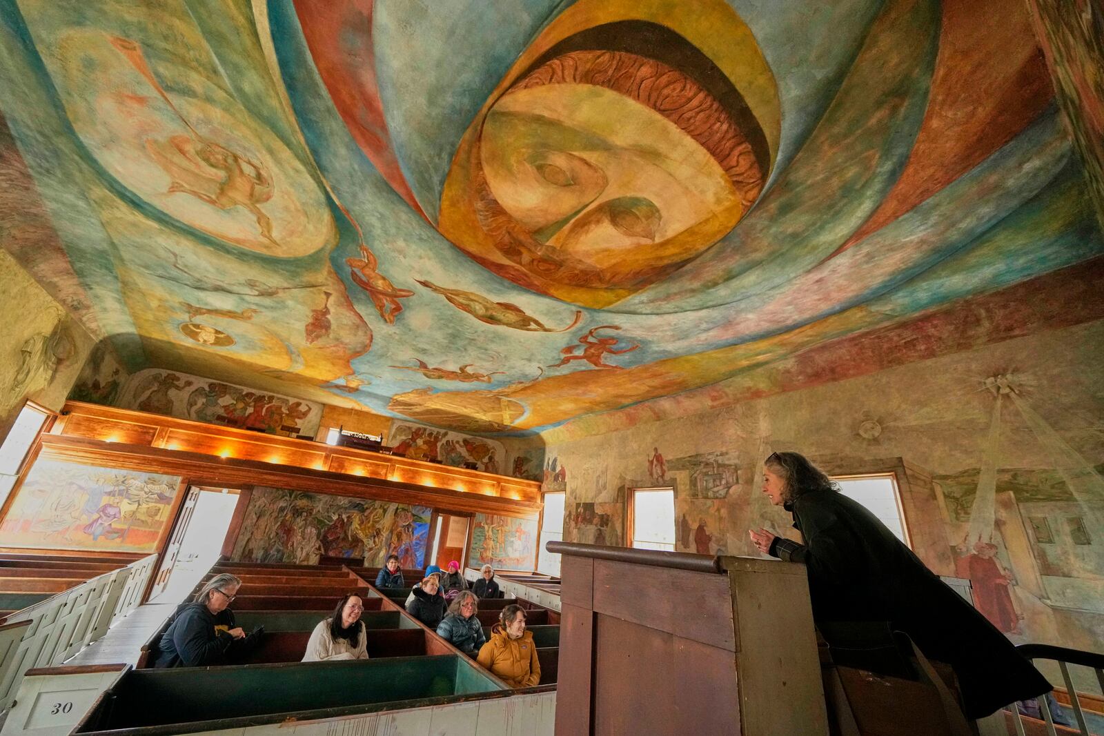 Veronique Plesch, an art professor at Colby College, gives a lecture to art teachers about the frescoes that adorn the walls and ceiling of the South Solon Meeting House, Sunday, April 6, 2025, in Solon, Maine. (AP Photo/Robert F. Bukaty)