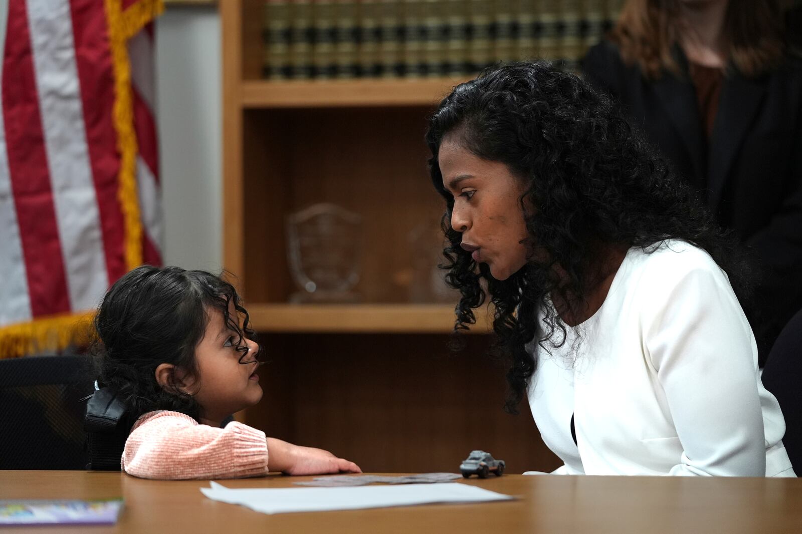 Deysi Vargas, left, talks to her 4-year-old daughter, who has short bowel syndrome, at a news conference in Los Angeles, Wednesday, May 28, 2025, after their humanitarian parole was terminated and they were ordered to self-deport. (AP Photo/Jae C. Hong)