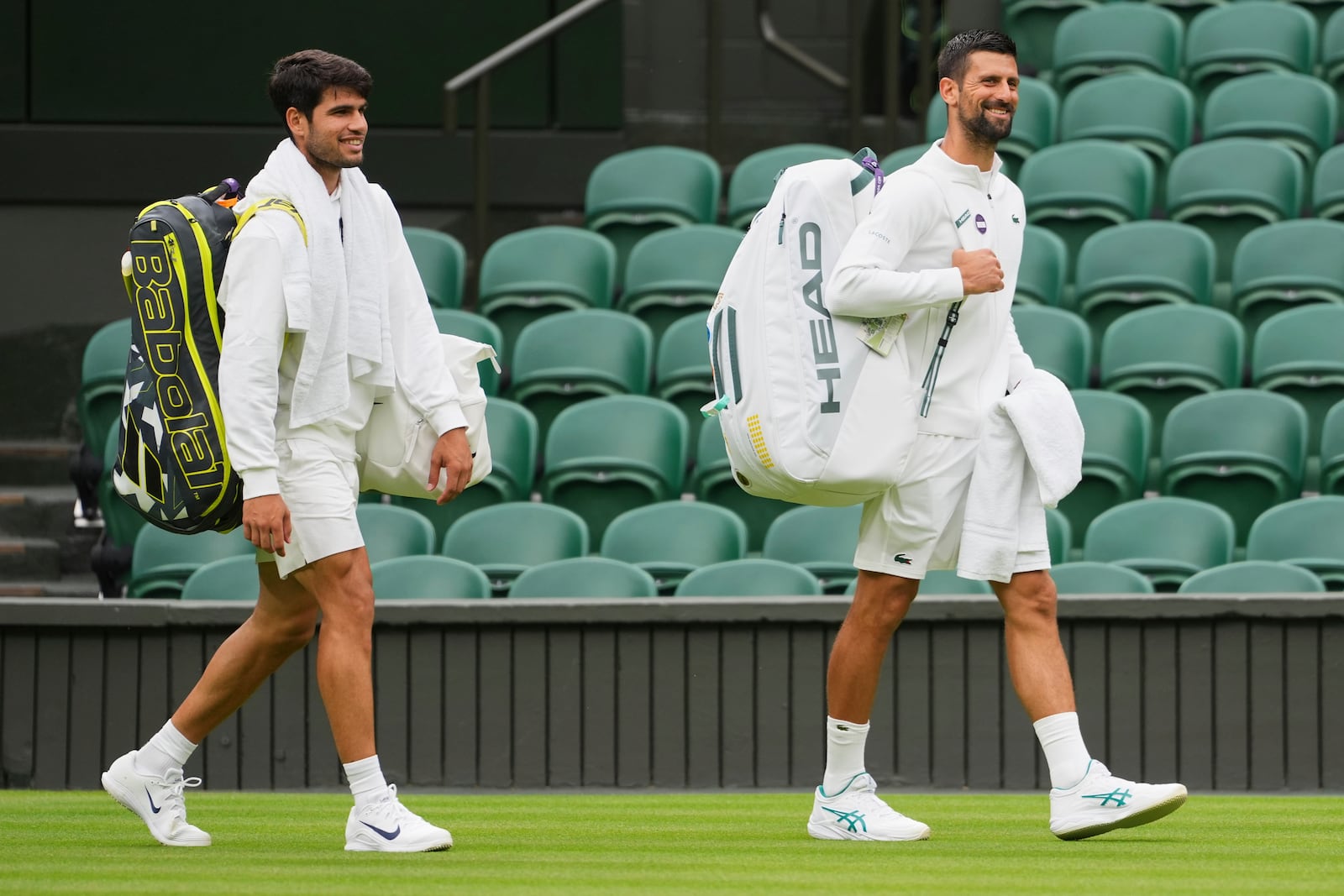Novak Djokovic of Serbia, right, and Carlos Alcaraz of Spain, left, arrive for a practice session on Centre Court at the All England Lawn Tennis and Croquet Club, ahead of the Wimbledon Championships in London, Thursday, June 26, 2025. (AP Photo/Kirsty Wigglesworth)