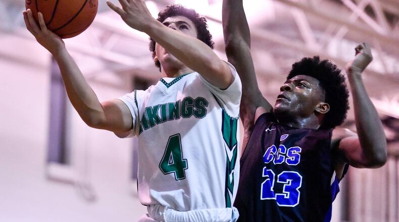 New Miami’s Deanza Duncan goes to the hoop while being defended by Cincinnati Christian’s Cameron Rogers during Friday night’s game at New Miami. CCS won 70-52. NICK GRAHAM/STAFF