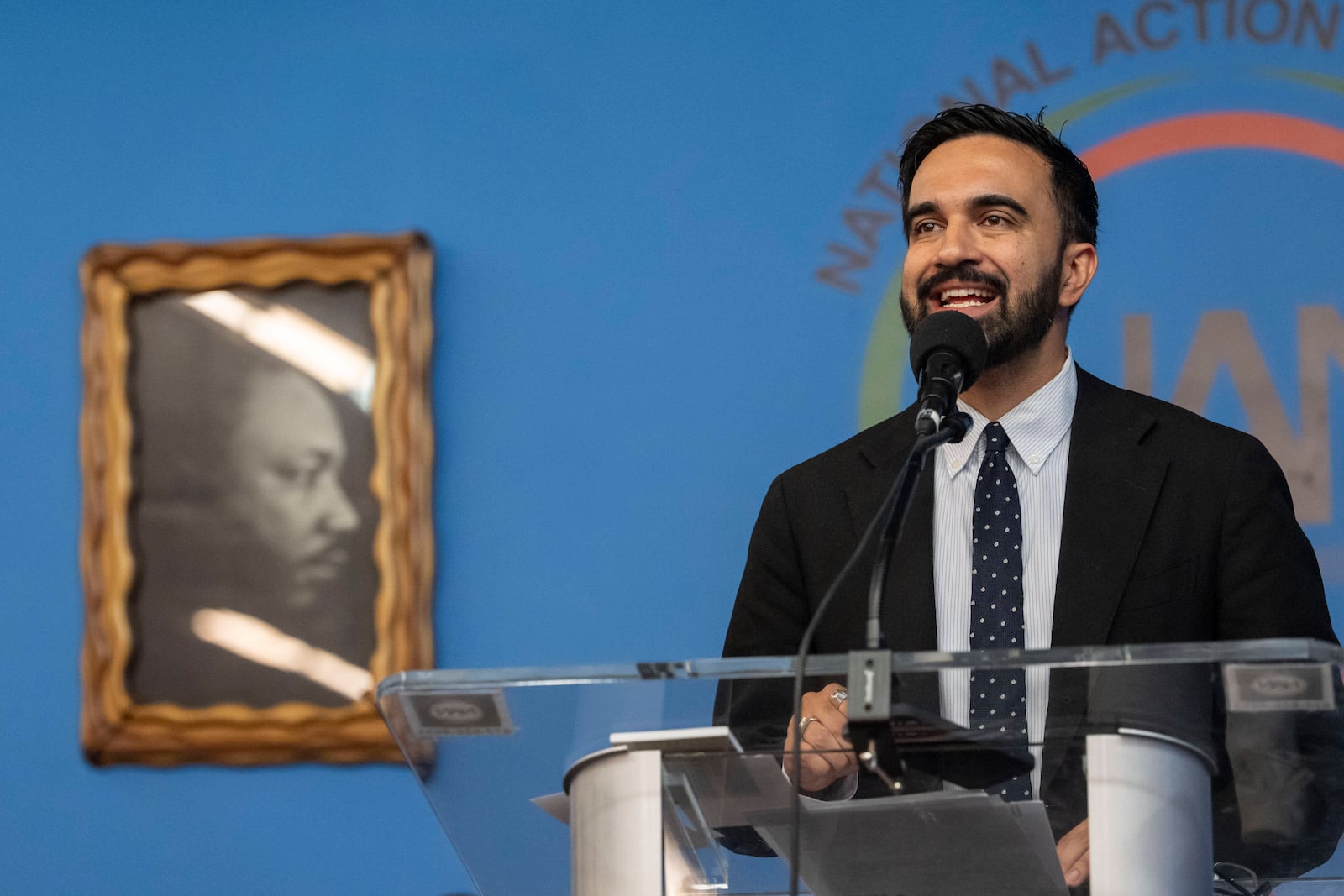 Democratic mayoral candidate Zohran Mamdani speaks next to a portrait of Martin Luther King Jr. during the National Action Network's Saturday action rally at House of Justice in Harlem, Saturday, June 28, 2025, in New York. (AP Photo/Yuki Iwamura)
