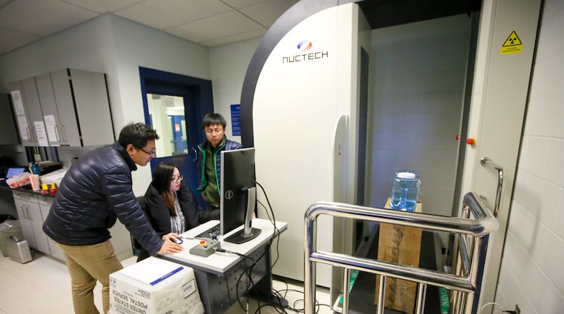 Jiajiang Zhao, Shenna Huang, and Bin Sang of Nuctech sets up a Body Inspection System at the Butler County Jail. GREG LYNCH / STAFF