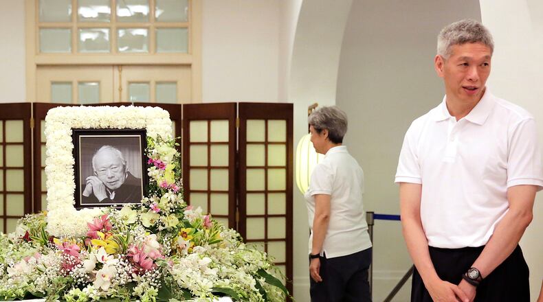 FILE - In this March 24, 2015, file photo, Prime Minister Lee Hsien Loong's brother, Lee Hsien Yang, right, receives friends and family members paying their respects to the late Lee Kuan Yew during a private family wake at the Istana or Presidential Palace in Singapore. (AP Photo/Wong Maye-E, File)