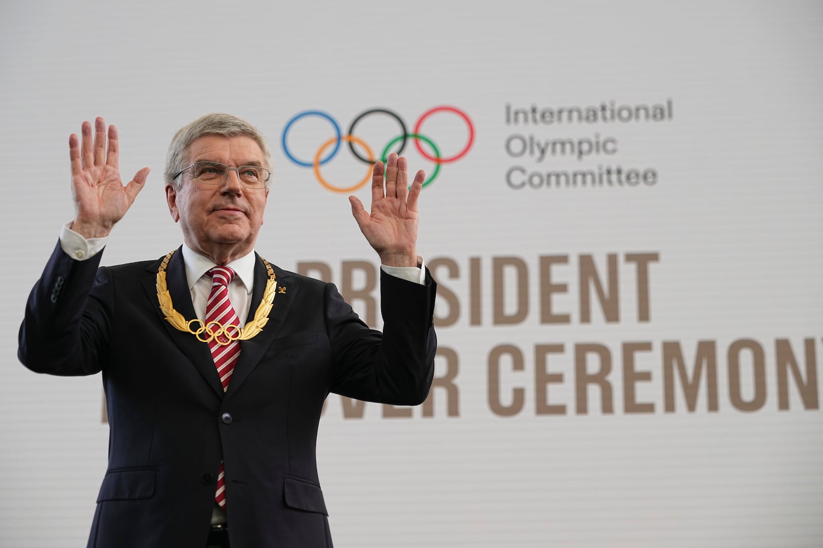 The outgoing IOC President Thomas Bach waves to the audience after receiving the Olympic order in gold prize during the handover ceremony of the IOC Presidency at Olympic House in Lausanne, Switzerland, Monday, June 23, 2025. (AP Photo/Laurent Cipriani)