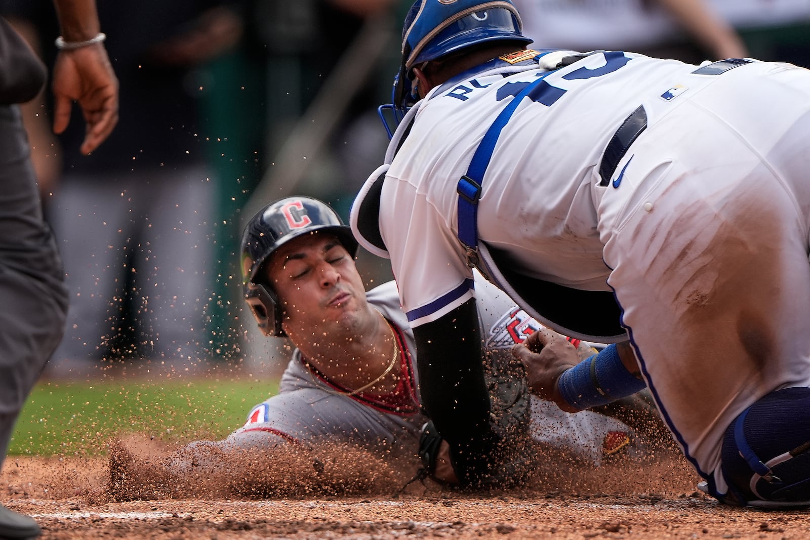 Cleveland Guardians' Brayan Rocchio, left, is tagged out at home by Kansas City Royals catcher Salvador Perez (13) as he tried to score on an RBI double by Bo Naylor during the seventh inning in the first baseball game of a doubleheader, Saturday, July 26, 2025, in Kansas City, Mo. (AP Photo/Charlie Riedel)
