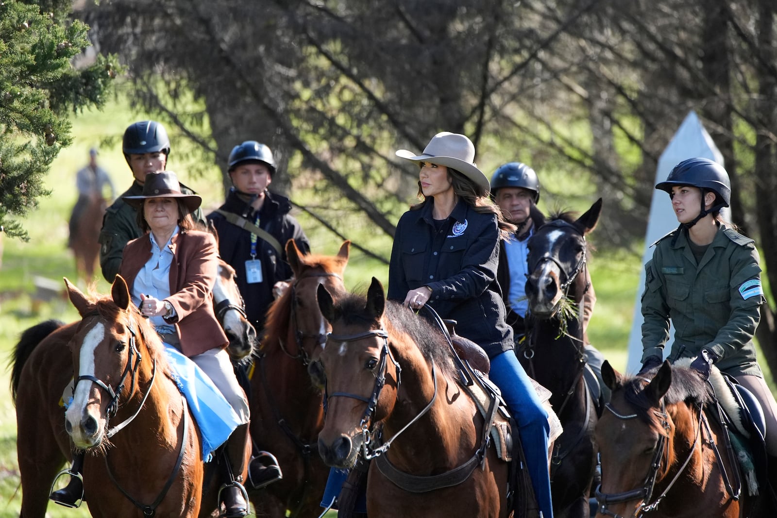U.S. Homeland Security Secretary Kristi Noem, center, and Argentine National Security Minister Patricia Bullrich, left, tour the Campo De Mayo Military Base on horseback in Buenos Aires province, Argentina, Monday, July 28, 2025. (AP Photo/Alex Brandon, Pool)