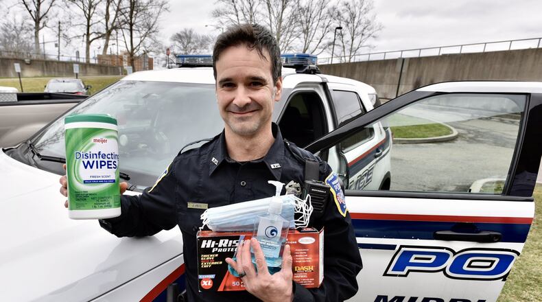 Middletown Division of Police officer Andrew Minic shows some of the items they are using to take extra precautions in the wake of the coronavirus outbreak. Officers are trying to minimize contact with the public as much as possible and sanitize when they are making contact. NICK GRAHAM / STAFF