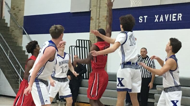 Lakota West’s Myles Greenwood (15) puts up a shot over St. Xavier’s Nathan Stockman (10) during a game at Berning Gym in Springfield Township on Jan. 17, 2018. RICK CASSANO/STAFF