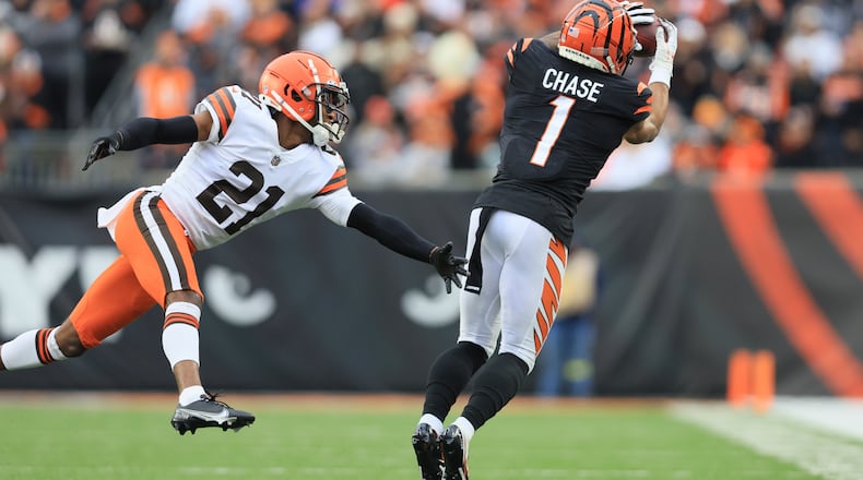 Cincinnati Bengals' Ja'Marr Chase (1) makes a catch against Cleveland Browns' Denzel Ward (21) during the second half of an NFL football game, Sunday, Dec. 11, 2022, in Cincinnati. (AP Photo/Aaron Doster)