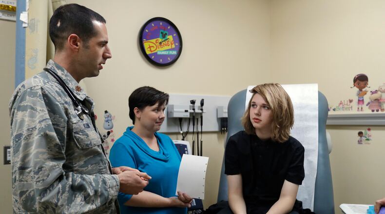 In this Sept. 7, 2016, photo, Dr. David Klein, an Air Force Major and chief of adolescent medicine at Fort Belvoir Community Hospital, left, speaks with Amanda Brewer and her daughter Jenn Brewer, 13, during the teenager's regular monthly doctors appointment for monitoring of her treatment at the hospital in Fort Belvoir, Va. Brewer is transitioning from male to female. Starting Oct. 3, the military’s health insurance will cover transgender-related services that include hormone therapy and supportive counseling.(AP Photo/Jacquelyn Martin)