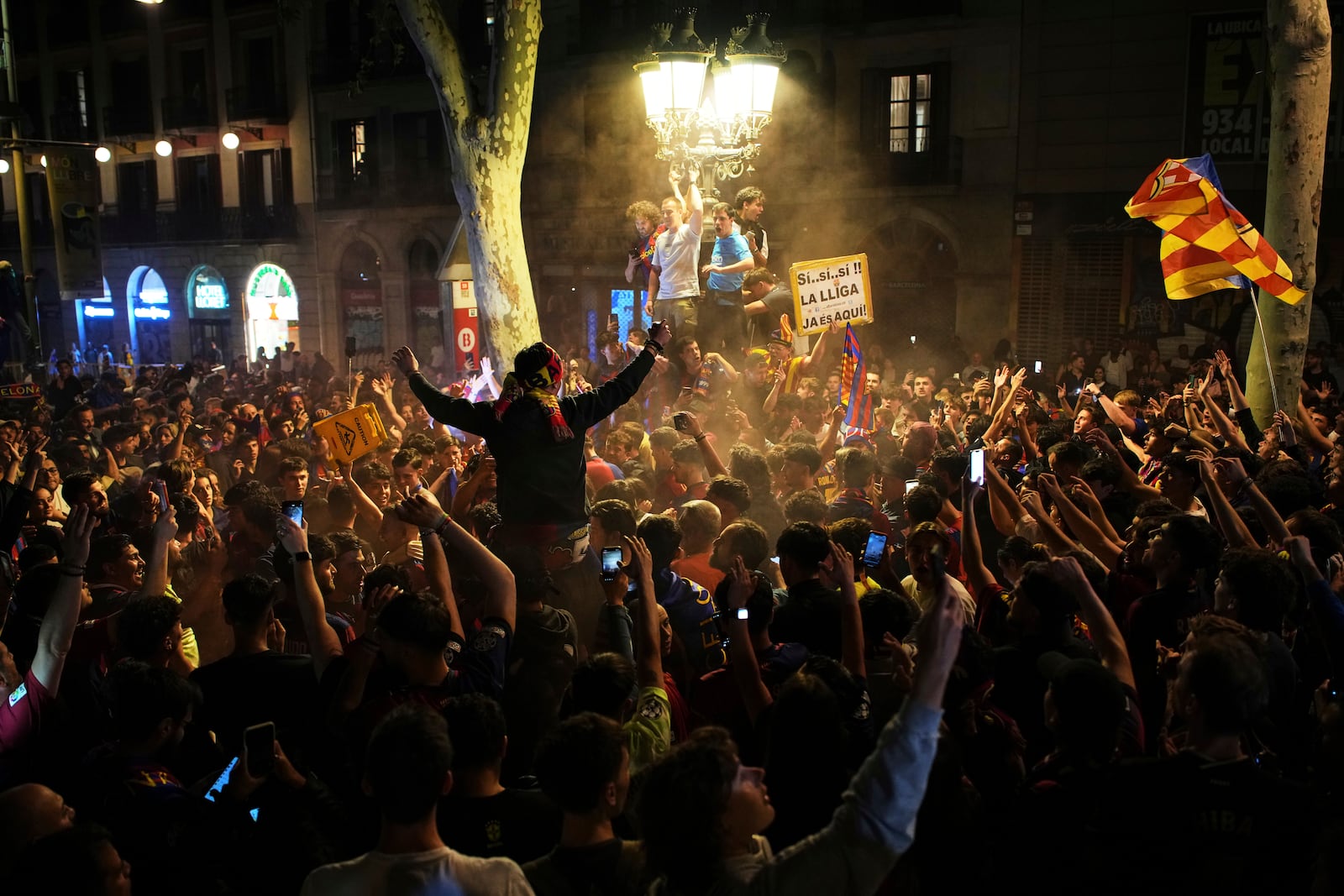 Barcelona fans celebrate in the street after their team won the Spanish La Liga soccer championship in Barcelona, Spain, Thursday, May 15, 2025. (AP Photo/Emilio Morenatti)