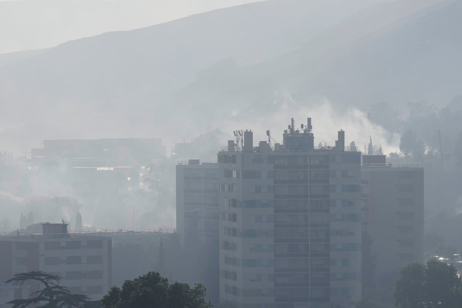 Smoke rises behind buildings during wildfire Tuesday, July 8, 2025 in La Catellane district of Marseille, southern France. (AP Photo/Lewis Joly)