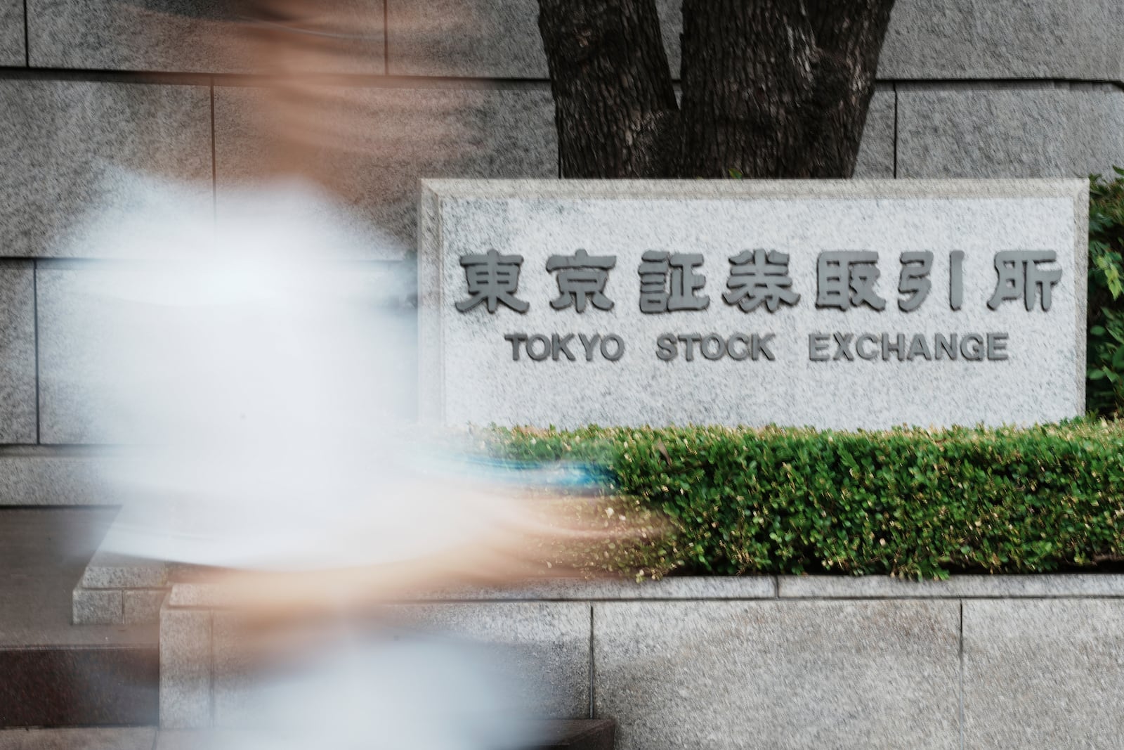 A person walks in front of Tokyo Stock Exchange building Friday, July 11, 2025, in Tokyo. (AP Photo/Eugene Hoshiko)