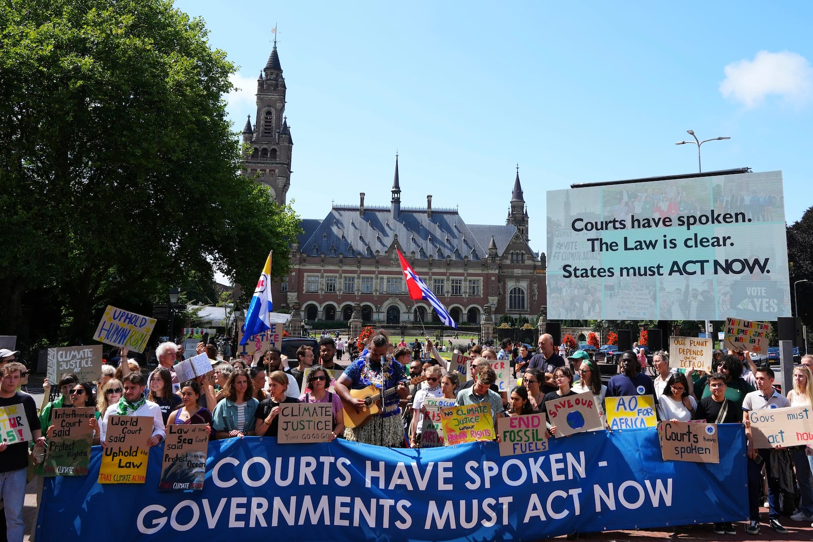 Activists demonstrate outside The Peace Palace, housing the International Court of Justice, ahead of an advisory opinion on what legal obligations nations have to address climate change and what consequences they may face if they don't, Wednesday, July 23, 2025, in The Hague, Netherlands. (AP Photo/Peter Dejong)