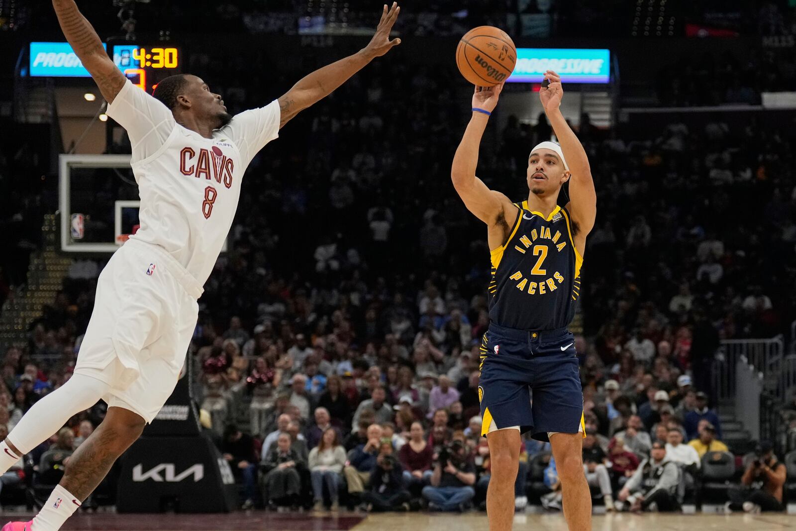 Indiana Pacers guard Andrew Nembhard (2) shoots as Cleveland Cavaliers guard Javonte Green (8) defends in the first half of an NBA basketball game Sunday, April 13, 2025, in Cleveland. (AP Photo/Sue Ogrocki)