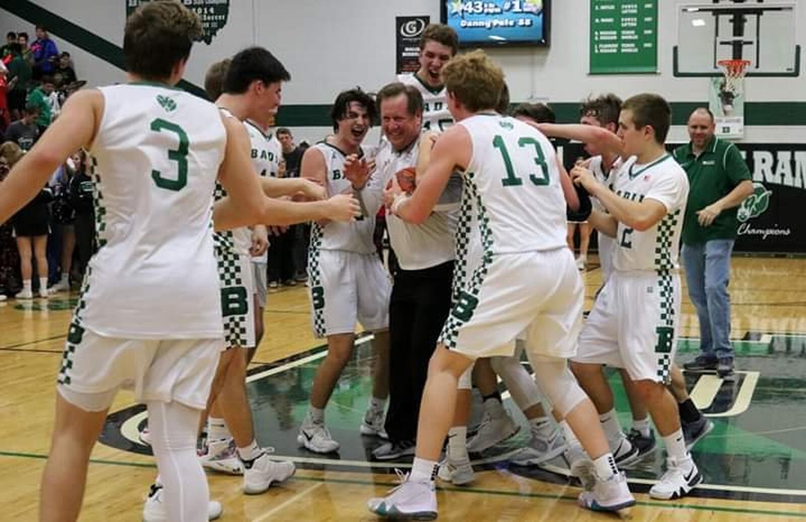 Badin coach Gerry Weisgerber is mobbed by his players after the Rams’ 43-42 victory over Carroll at Mulcahey Gym in Hamilton on Friday night. It was the 300th win of Weisgerber’s coaching career. CONTRIBUTED PHOTO BY TERRI ADAMS