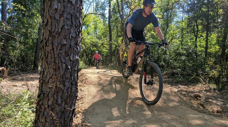 Scott Nash, a teacher in Lebanon, heads downhill on the mountain bike trails at the Premier Health Atrium Medical Center Bike Park in Lebanon. His daughter Kendall is trailing him.