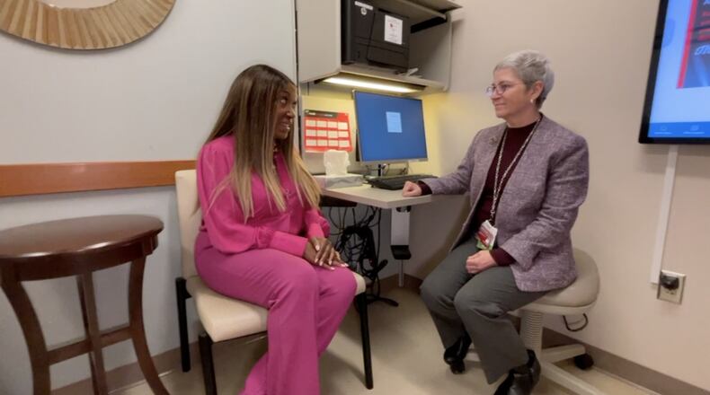 Dr. Elizabeth Shaughnessy, UC Health division director of cancer survivorship, talks with Sharen King. King was her patient as she received treatment for breast cancer in 2020. MARC PRICE/WCPO