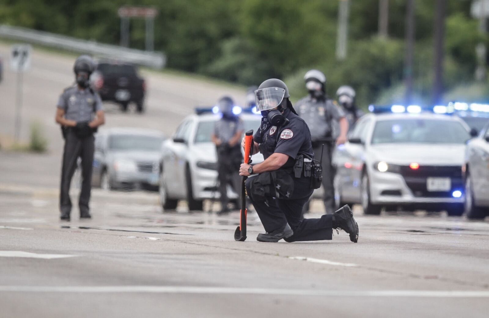 Cheers erupted after one officer took a knee. Two minutes later, a second officer took a knee, and, shortly after, three more Beavercreek officers took a knee. Other officers dropped their shields on the pavement. JIM NOELKER/STAFF