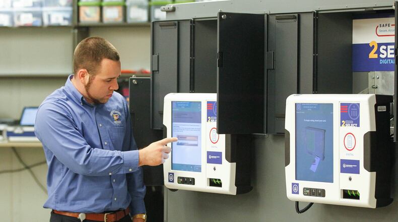 Nick Latessa, an elections operation supervisor at the Montgomery County Board of Elections, demonstrates voting technology on Wednesday during a visit by Ohio Secretary of State Frank LaRose. CHRIS STEWART / STAFF