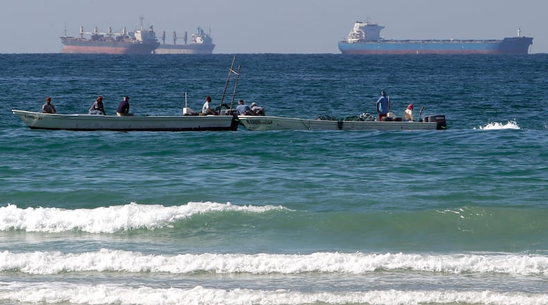 FILE - Fishermen work in front of oil tankers south of the Strait of Hormuz Jan. 19, 2012, offshore the town of Ras Al Khaimah in United Arab Emirates. (AP Photo/Kamran Jebreili, File)