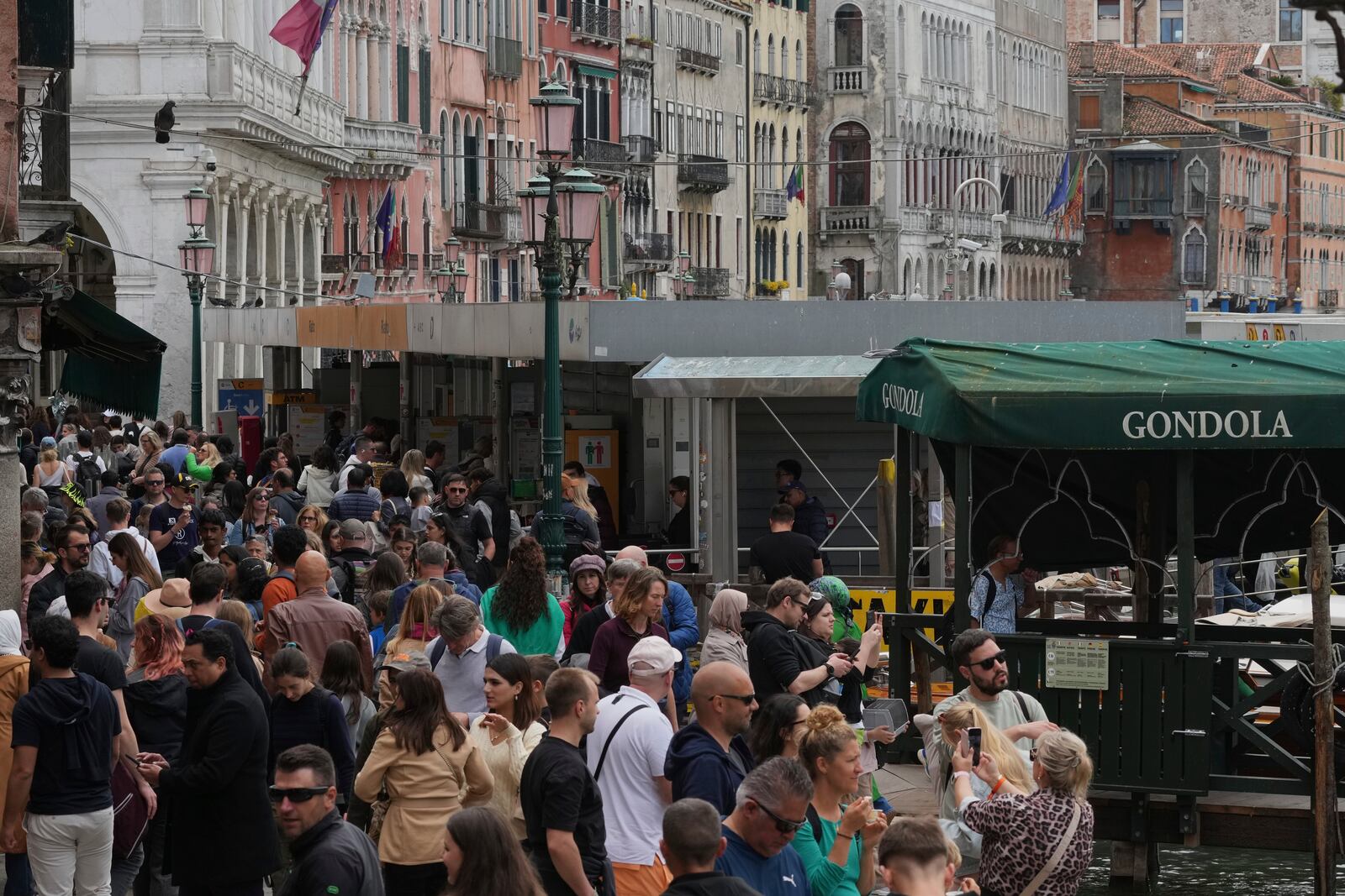 Tourists walk in Venice, Italy, Friday, April 18, 2025, Venice on Friday launches for a second year a pilot program to charge day-trippers an entrance fee. (AP Photo/Antonio Calanni)