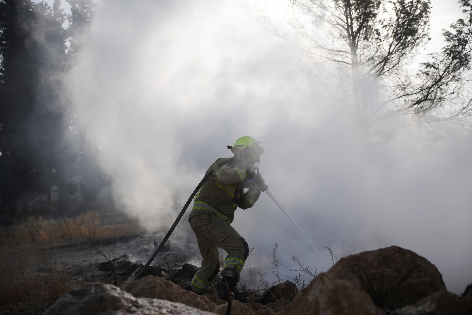 An Israeli firefighter battles a wild fire near Latrun, Israel, outside of Jerusalem Thursday, May 1, 2025. (AP Photo/Ohad Zwigenberg)