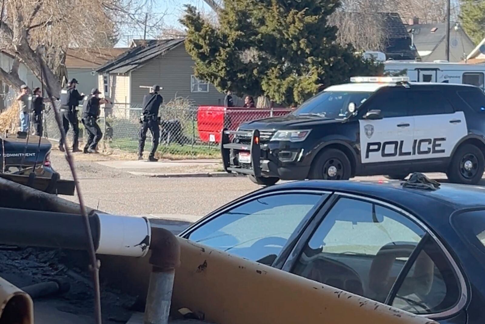 In this image made from video, police are seen shortly before opening fire on a teen on the other other side of a fence Saturday, April 5, 2025, in Pocatello, Idaho. (Brad Andres via AP)