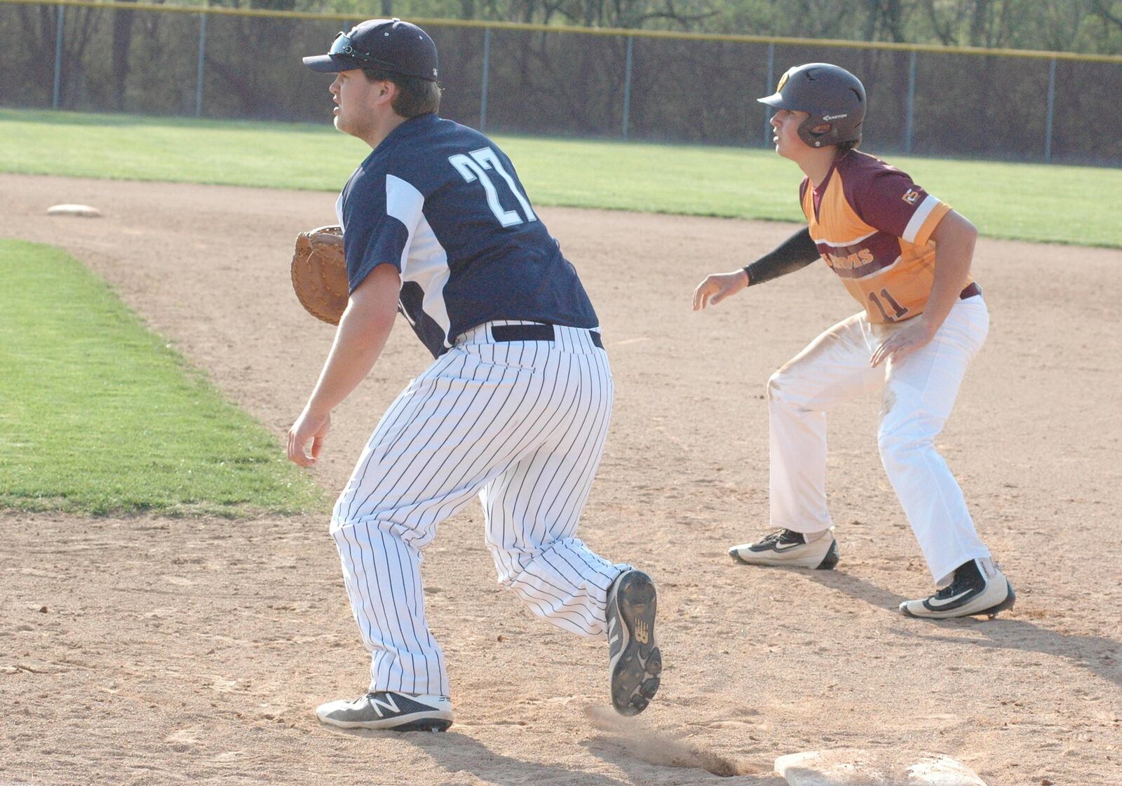 Edgewood first baseman Max Collett (27) and Tyler Hoover of Ross keep their eyes on the ball Wednesday in Ross Township. Ross beat EHS 13-9 in a Southwest Ohio Conference baseball game. RICK CASSANO/STAFF