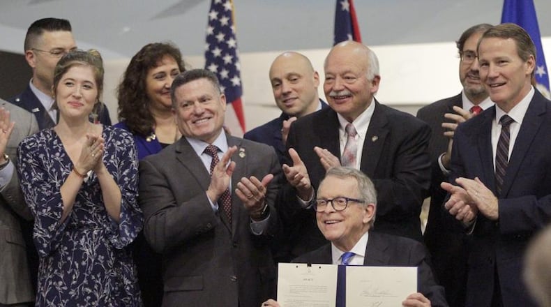 Gov. Mike DeWine signed Ohio Senate Bill 7 in January during a ceremony at the National Museum of the U.S. Air Force. From left to right are Brianna McKinnon, a military spouse and special education teacher, Rep. Rick Perales, Sen. Bob Hackett and Lt. Gov. Jon Husted. LISA POWELL / STAFF