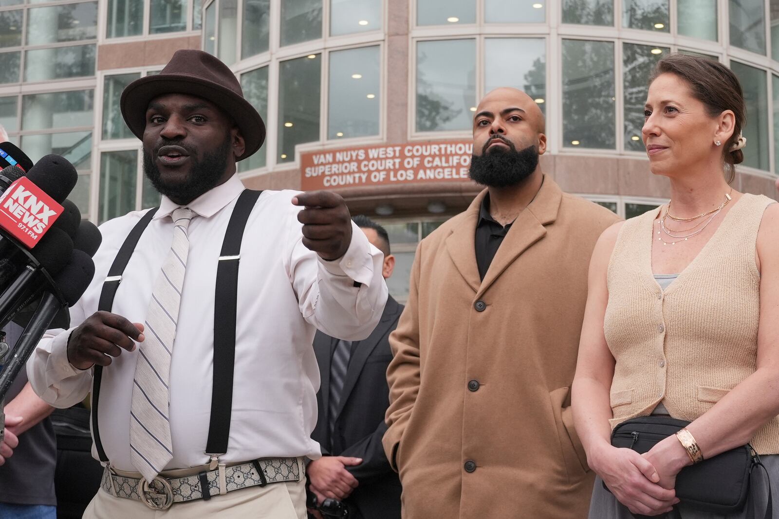 Anerae Brown, left, speaks to the media next to other supporters of Erik and Lyle Menendez, who were sentenced in 1996 to life in prison without the possibility of parole for fatally shooting their parents, after a resentencing hearing in their case, Thursday, April 17, 2025, in Los Angeles. (AP Photo/Damian Dovarganes)