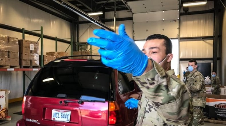 The Ohio National Guard helps direct traffic during a July 23, 2020, drive-thru food distribution event at The Foodbank in Dayton. STAFF