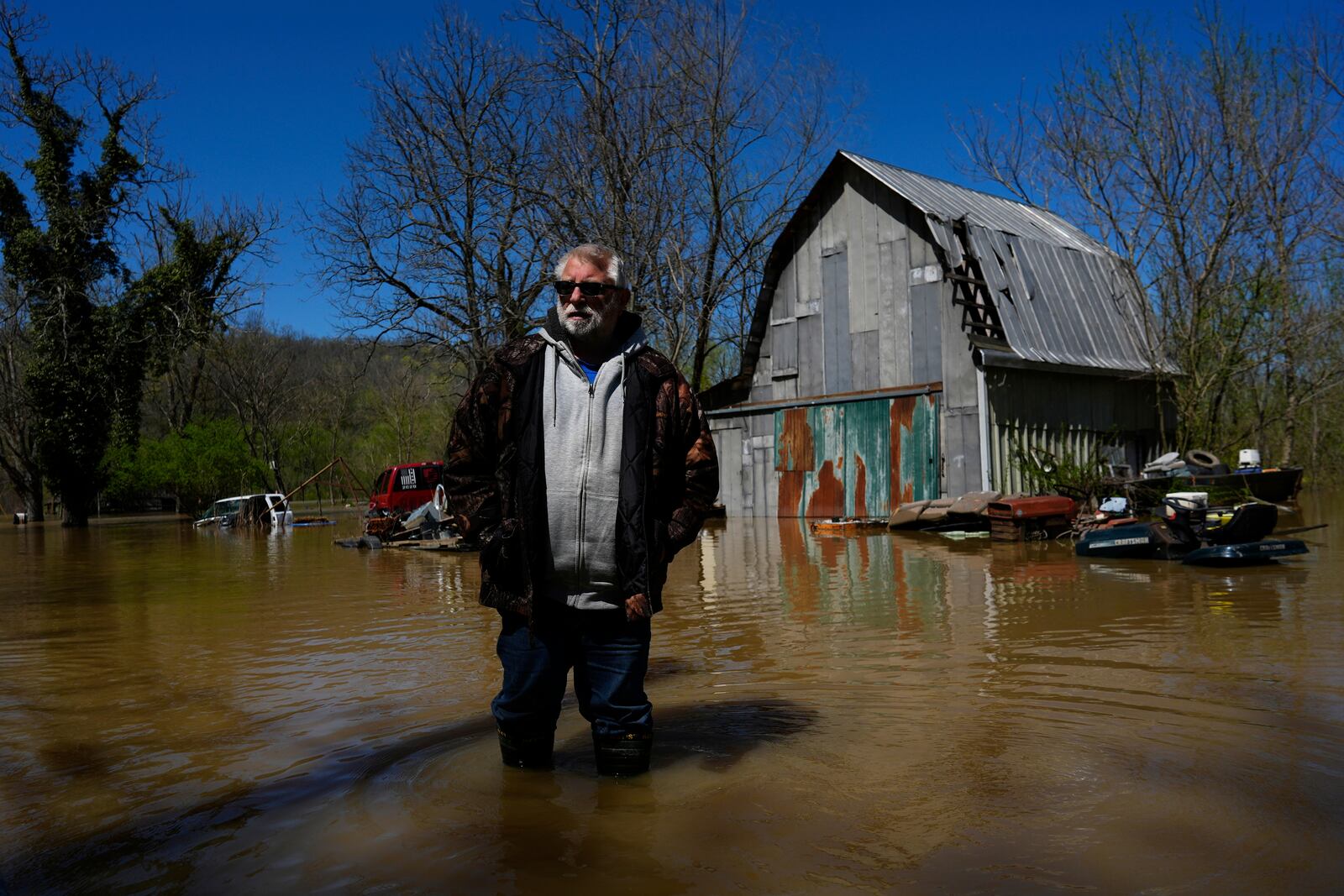 James Harp, Jr., stands in Kentucky River floodwaters in a barnyard in Lockport, Ky., Tuesday, April 8, 2025. (AP Photo/Carolyn Kaster)