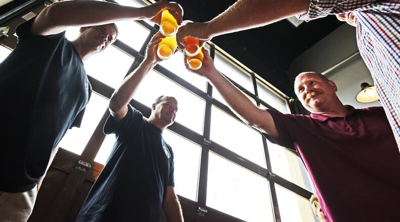 Hamilton’s Municipal Brew Works will again tap its special Woltermelon Blonde Ale to honor fallen firefighter Patrick Wolterman. A ceremonial first pour and toast is set for Aug. 26, according to the brewery’s CEO. Pictured are friends are family of Wolterman during the beer’s 2016 limited release. NICK GRAHAM/2016